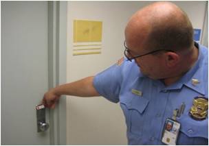 Police officer placing a red seal on a door