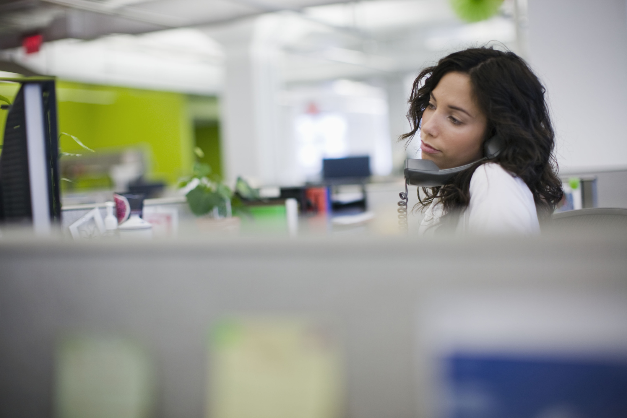 Picture of woman at computer and on phone